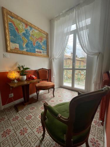 a living room with a chair and a window at Les volets verts in Saint-Laurent-de-la-Cabrerisse