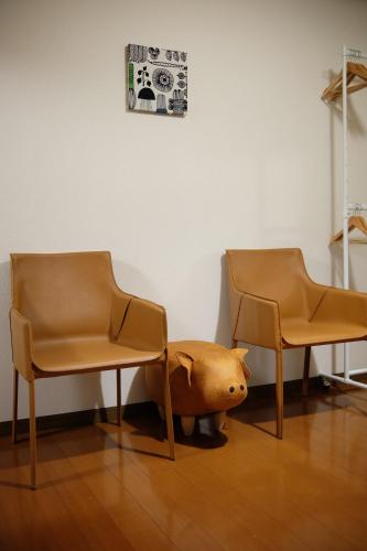 two chairs and a stuffed pig under a table at 1日1組限定 5LDKお洒落古民家 駐車場2台 夜景を望む宿 "一休庵" Traditional house with yard and parking in Hiroshima
