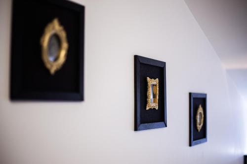 a group of framed clocks on a wall at Le Logis de la Gabirotte in Nieulle-sur-Seudre