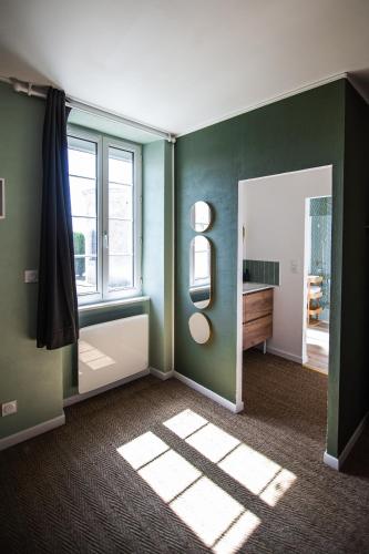 a bathroom with green walls and a window and a mirror at Le Logis de la Gabirotte in Nieulle-sur-Seudre