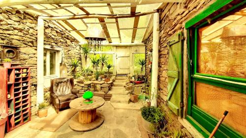 un patio avec une table et des chaises et un mur en pierre dans l'établissement L'atelier de joakim, à Seix