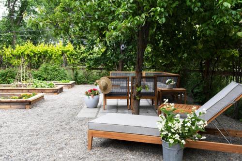 a patio with benches and tables in a garden at Emtec Farm Accommodation in Magaliesburg