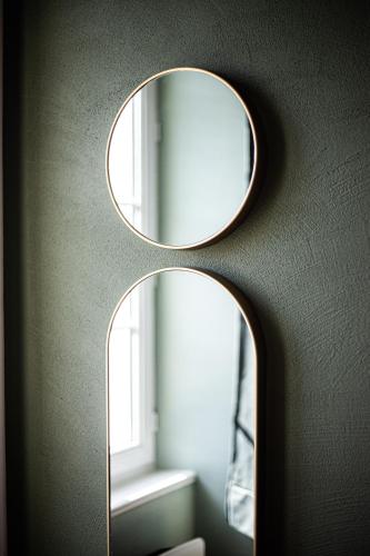 a mirror on the side of a wall with a window at Le Logis de la Gabirotte in Nieulle-sur-Seudre