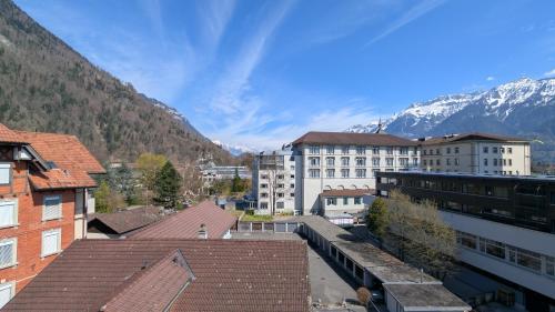 a city with buildings and mountains in the background at Hotel Harder Minerva in Interlaken