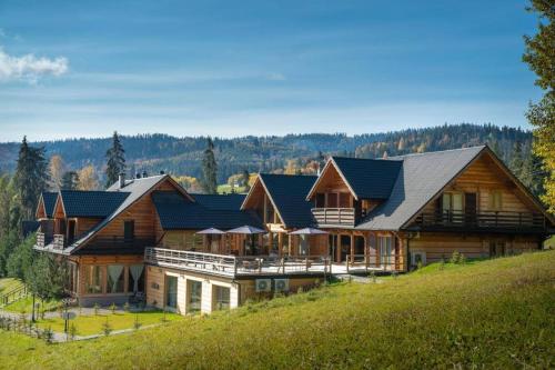a large wooden house on a hill at domki z dostępem do SPA i restauracji in Łapsze Niżne