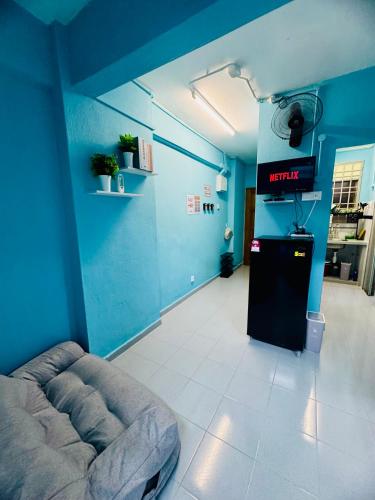 a blue room with a couch and a television in it at Apartment in gelugor usm in Gelugor