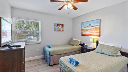 een slaapkamer met twee bedden en een plafondventilator bij Beneva Brooke Beauty in Sarasota