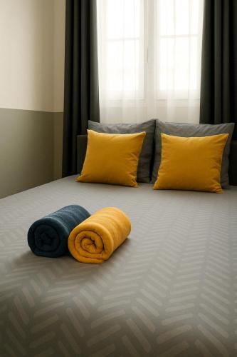 - un lit avec 2 oreillers et 2 serviettes dans l'établissement Studette Sable & Mer cosy à 100m de la plage, à Merville-Franceville-Plage