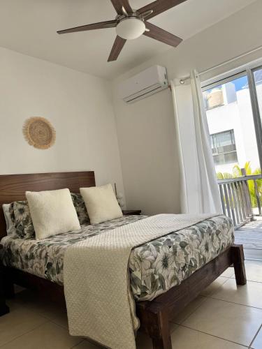 Un dormitorio con una cama con ventilador de techo. en Casa Chanel México, en Playa del Carmen