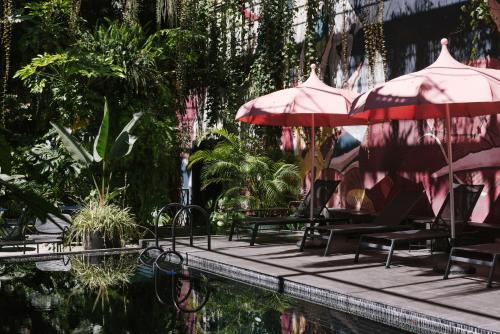 a pool with tables and umbrellas and chairs next to a swimming pool at Hotel Hotel - Member of Design Hotels in Lisbon