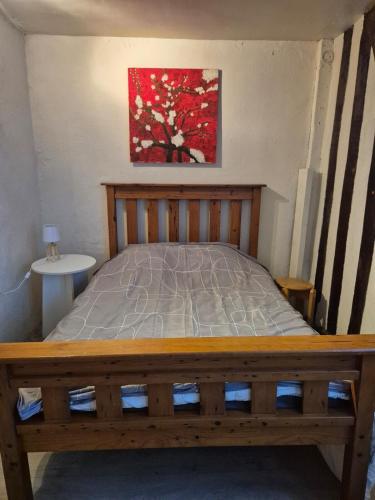 un lit dans une chambre avec un tableau sur le mur dans l'établissement Honfleur évasion, à Honfleur