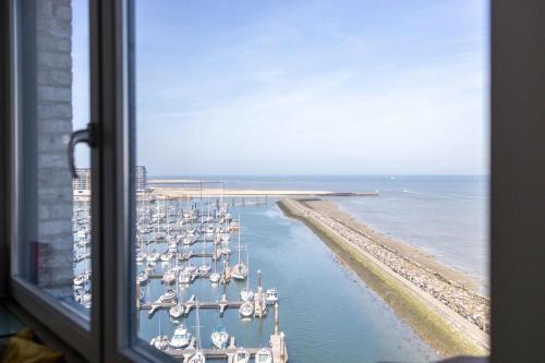 a view from a window of a marina with boats at Hello Zeeland - Appartement Port Scaldis 01-081 in Breskens