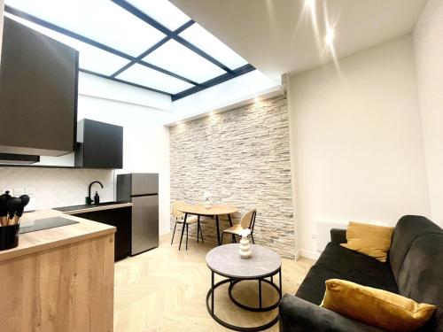 un salon avec un canapé et une table dans l'établissement Charming & Cozy Flat - Clichy, à Clichy