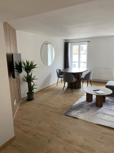 un salon avec une table et des chaises dans l'établissement Le Refuge Balnéo - Nature & Bien-Être à Saint Dié, à Saint-Dié-des-Vosges