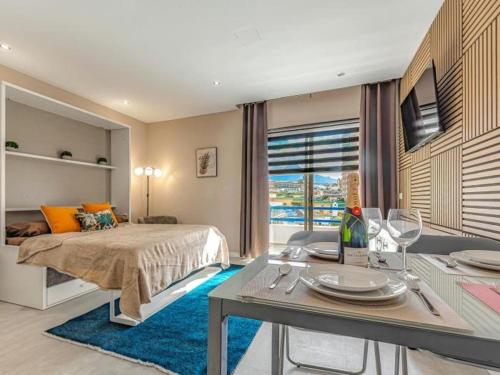 ein Schlafzimmer mit einem Bett und einem Tisch mit Tellern und Weingläsern in der Unterkunft 309 Paraiso Sur luxury Studio in Playa Paraiso