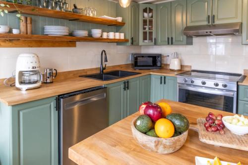 a kitchen with a bowl of fruit on a counter at Maison du Village - Nature Beach Bike & Village in Eastman