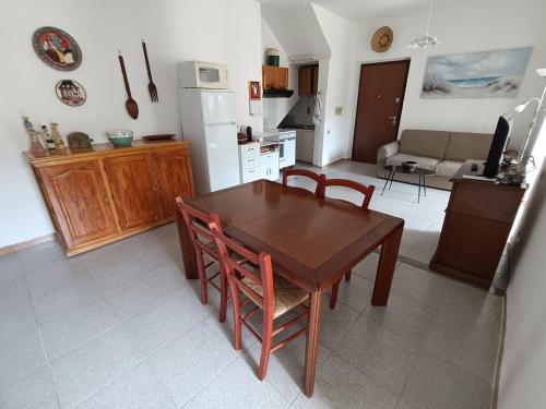 a kitchen and dining room with a wooden table and chairs at Holiday House 120sqm Garden in Carbonia