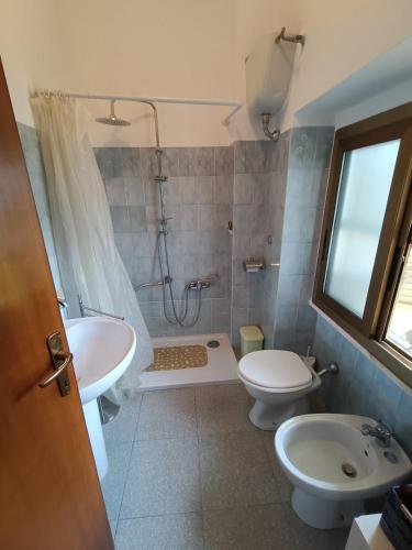 a bathroom with a shower and a toilet and a sink at Holiday House 120sqm Garden in Carbonia