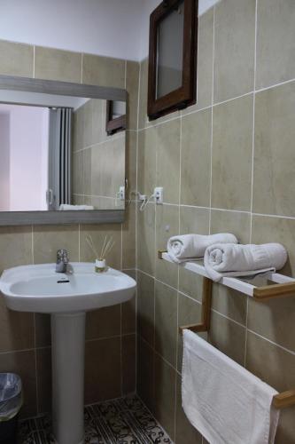 グラナダにあるcasa mirador de san miguelの洗面台、鏡、タオルを備えたバスルーム