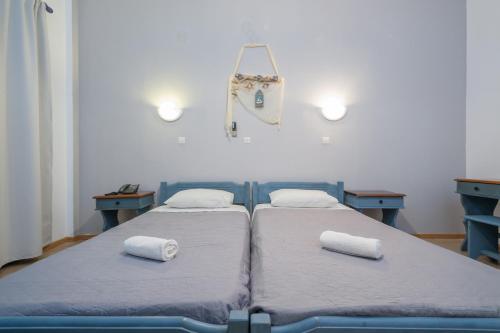 two beds in a hospital room with towels on them at To Kyma in Moudhros
