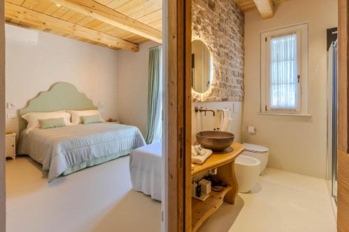 a bathroom with a bed and a sink in a room at Villa Petra in Capodarco