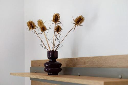 a black vase with dried flowers in it on a table at Wiesenblick in Ciardes