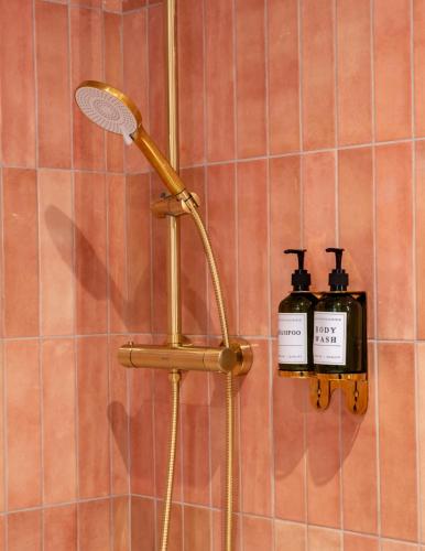 a shower with a shower head on a wall at The Woodquay Townhouse in Galway