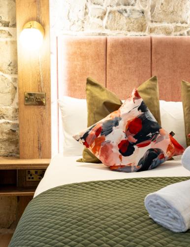 a bed with two pillows on it in a room at The Woodquay Townhouse in Galway