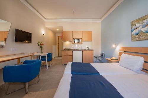 a hotel room with a bed and a kitchen at Xemxija Bay Hotel in St Paul's Bay
