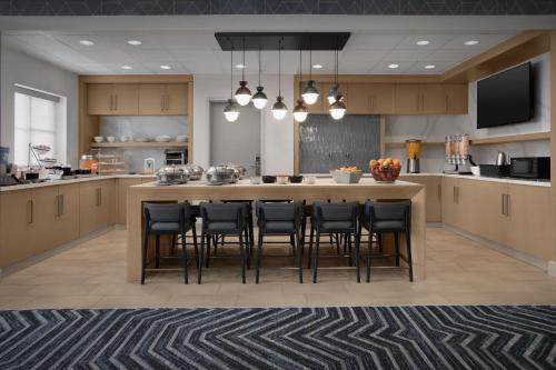 an open kitchen with a large island with bar stools at Homewood Suites by Hilton Colorado Springs North USAFA in Colorado Springs