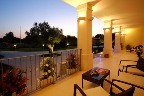 a porch with chairs and a table on a balcony at Willaria Country House in Cursi
