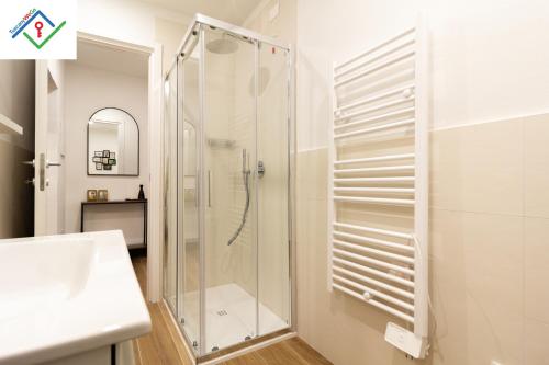 a white bathroom with a shower and a sink at Loggia Del Mazzei by TuscanyWeGo in Prato