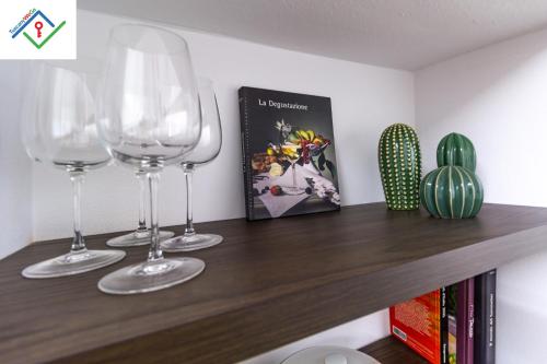 three wine glasses sitting on top of a wooden shelf at Loggia Del Mazzei by TuscanyWeGo in Prato