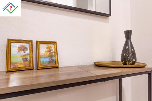 a vase sitting on a counter with three paintings at Loggia Del Mazzei by TuscanyWeGo in Prato