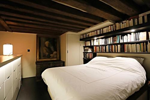 - une chambre avec un lit blanc et des étagères dans l'établissement My Terrace Of Paris, à Paris