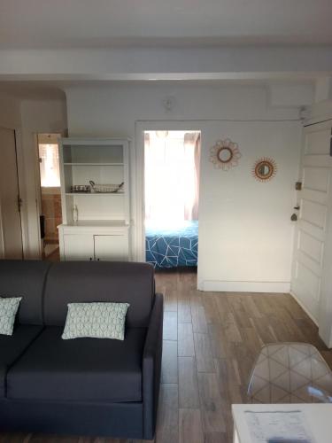 un salon avec un canapé et une fenêtre dans l'établissement T2 bord de mer avec grand jardin, à Six-Fours-les-Plages