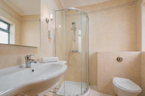 a bathroom with a shower and a sink and a toilet at Xemxija Bay Hotel in St Paul's Bay