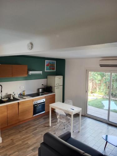 une cuisine et un salon avec une table et un canapé dans l'établissement T2 bord de mer avec grand jardin, à Six-Fours-les-Plages