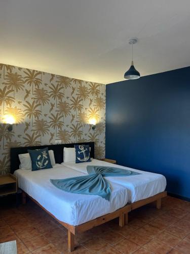 a bedroom with a large bed with a blue wall at Hostal Baleàric in San Antonio