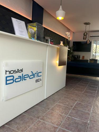 a reception area of a restaurant with a sign on a counter at Hostal Baleàric in San Antonio