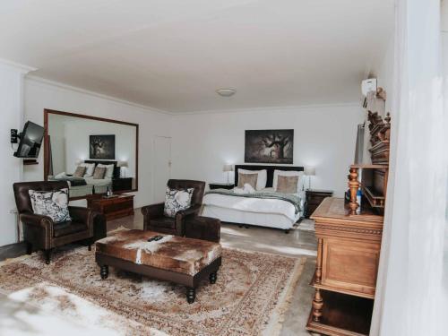 a bedroom with a bed and a table and chairs at Upington African Vineyard Boutique Hotel & SPA in Kanoneiland
