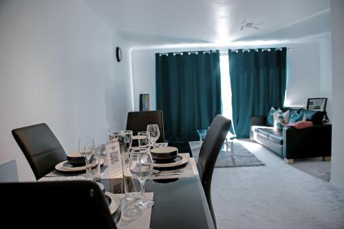 a dining room with a table with wine glasses on it at TMS Chic 3BDR house! Colchester! in Abberton