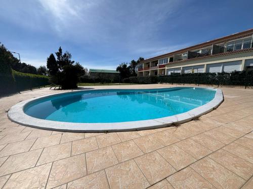 une grande piscine dans une cour avec un bâtiment dans l'établissement Appart4 pers clim parking piscine, à Antibes