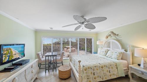 a bedroom with a bed and a television and a table at Las Hermanas 4 in Longboat Key