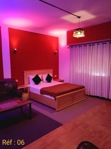 a bedroom with a bed and a purple lighting at Confort et détente en plein coeur de Rabat in Rabat