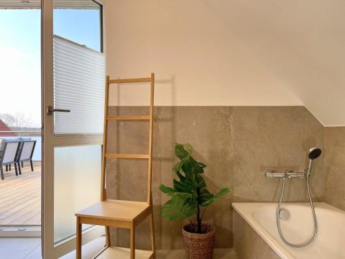 baño con bañera y planta en Am Dahmer Leuchtturm 23e, en Dahme