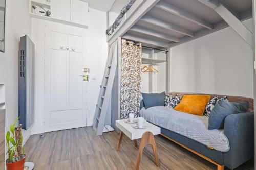 un salon avec un canapé bleu et une échelle dans l'établissement Studio calme en plein Paris, à Paris