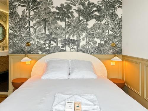 une chambre avec un lit avec un papier peint tropical dans l'établissement La suite de Jacobin - Luxe - Centre Historique, à Rennes