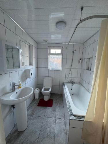 a bathroom with a sink and a toilet and a tub at Cozy room 7 in London