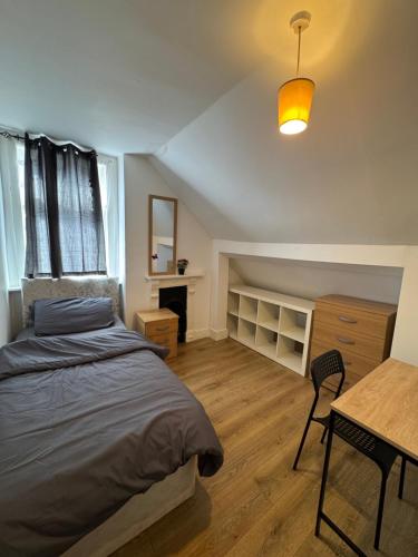 a bedroom with a bed and a desk and a table at Cozy room 7 in London